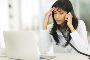 tired indian businesswoman using landline phone