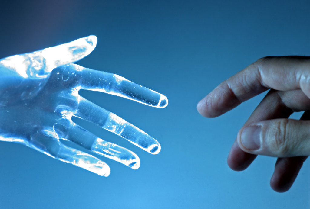 Human hand touch an atrifical glass hand